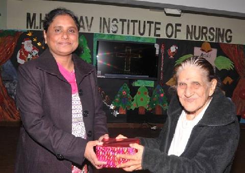 Honorable Chief Guest Mrs. Zeenat Williams giving X-mas Gift to Respected Principal Madam Mrs. Veena Williams
